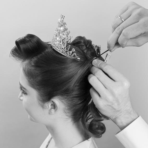 Eine Opernballfrisur wird mit einer Tiara und Haarnadeln befestigt: Schritt 8.