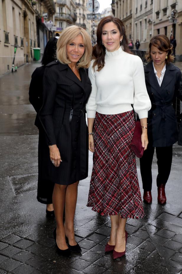 Brigitte Macron und Kronprinzessin Mary von Dänemark posieren auf einer Straße in Paris.