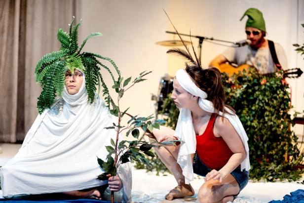 Eine Szene aus einem Theaterstück mit drei Darstellern in Kostümen.