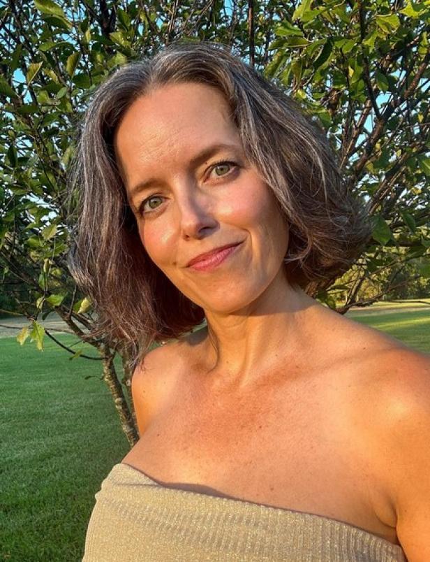 Penelope Springman posiert vor einem Baum im Freien.