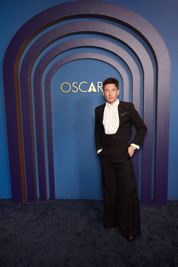 Barry Keoghan posiert vor einem blauen Hintergrund mit dem Oscar-Logo.