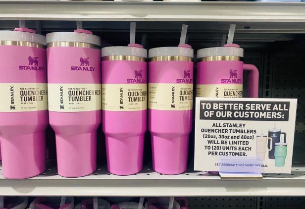 Eine Reihe von rosa Stanley Quencher Trinkbechern in verschiedenen Größen steht in einem Regal.