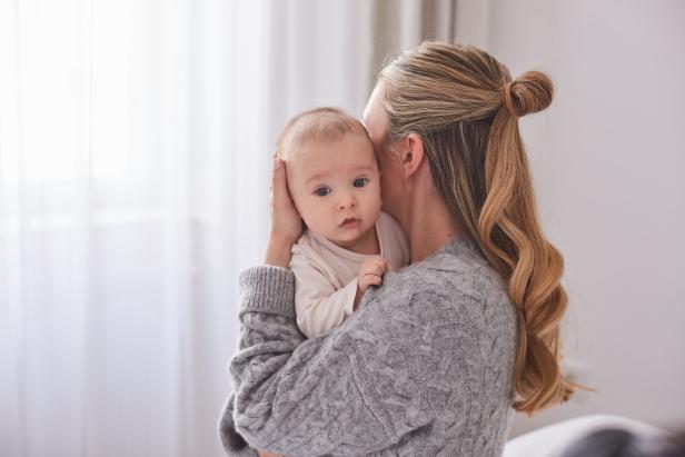 Eine Mutter hält ihr Baby im Arm.