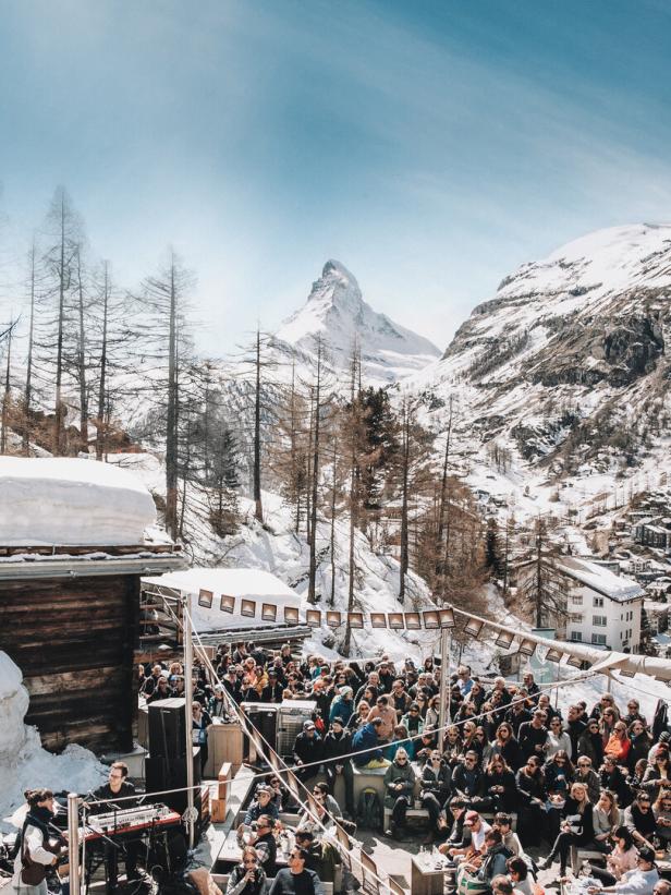 Eine Menschenmenge genießt ein Konzert im Freien vor der Kulisse des Matterhorns.