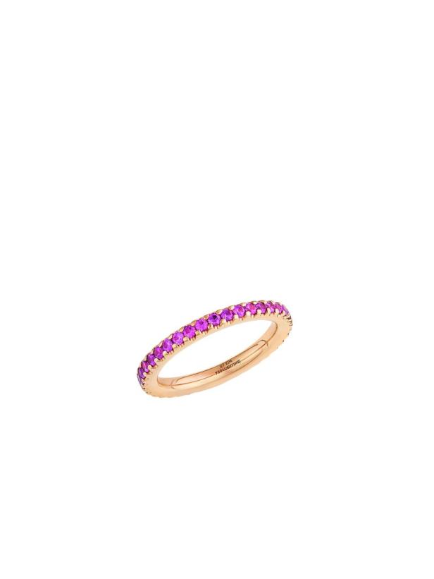 Ein schmaler, goldener Ring ist mit kleinen, pinkfarbenen Steinen besetzt.