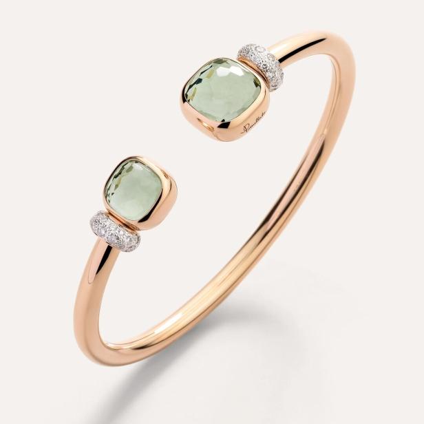 Ein offener Armreif aus Roségold mit zwei quadratischen, hellgrünen Steinen und Diamanten.