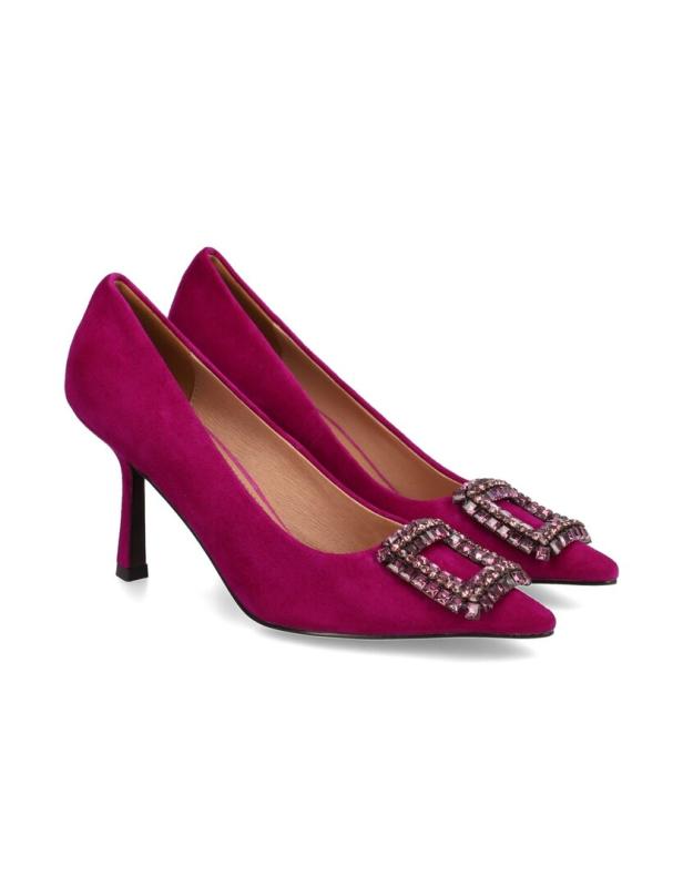 Ein Paar pinkfarbene Wildleder-Pumps mit Strass-Schnalle stehen auf einem weißen Hintergrund.