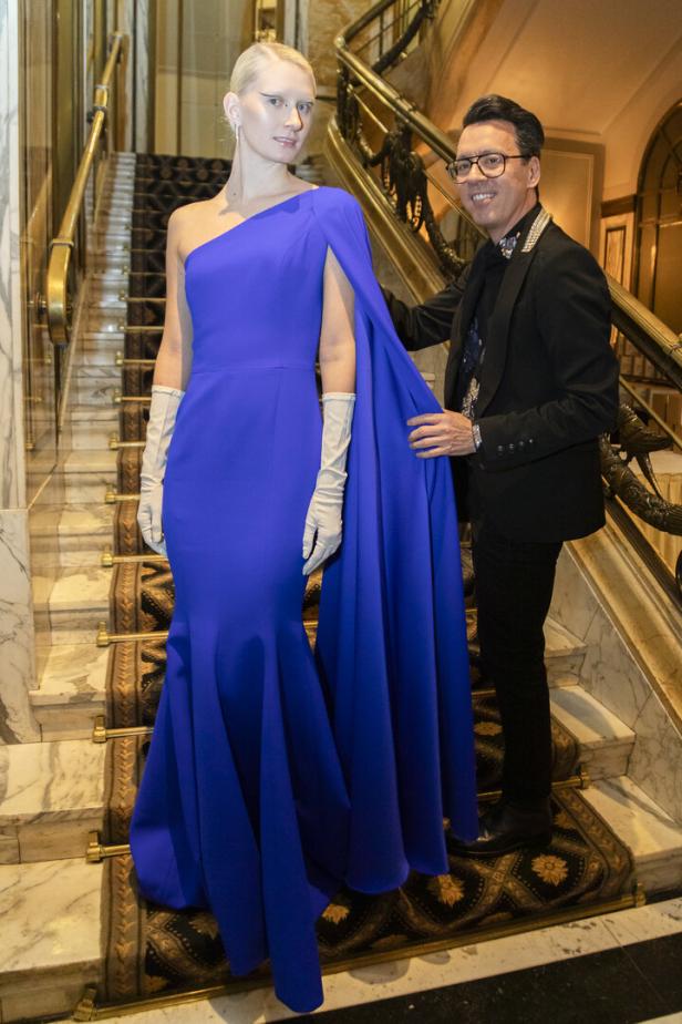 Eine Frau in einem blauen Kleid posiert mit einem Mann auf einer Treppe.