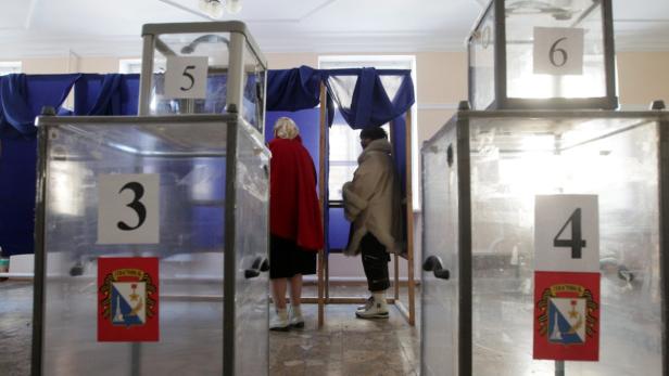 Wähler geben in nummerierten Wahlkabinen ihre Stimme ab.