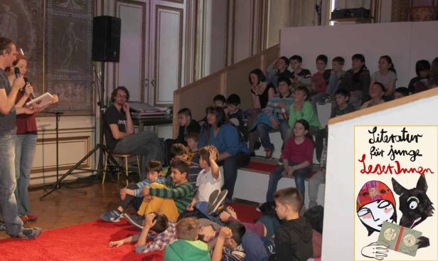 Eine Gruppe Kinder sitzt auf einer Treppe und hört einer Lesung zu.