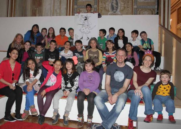 Eine Gruppe von Kindern und Erwachsenen posiert für ein Gruppenfoto.