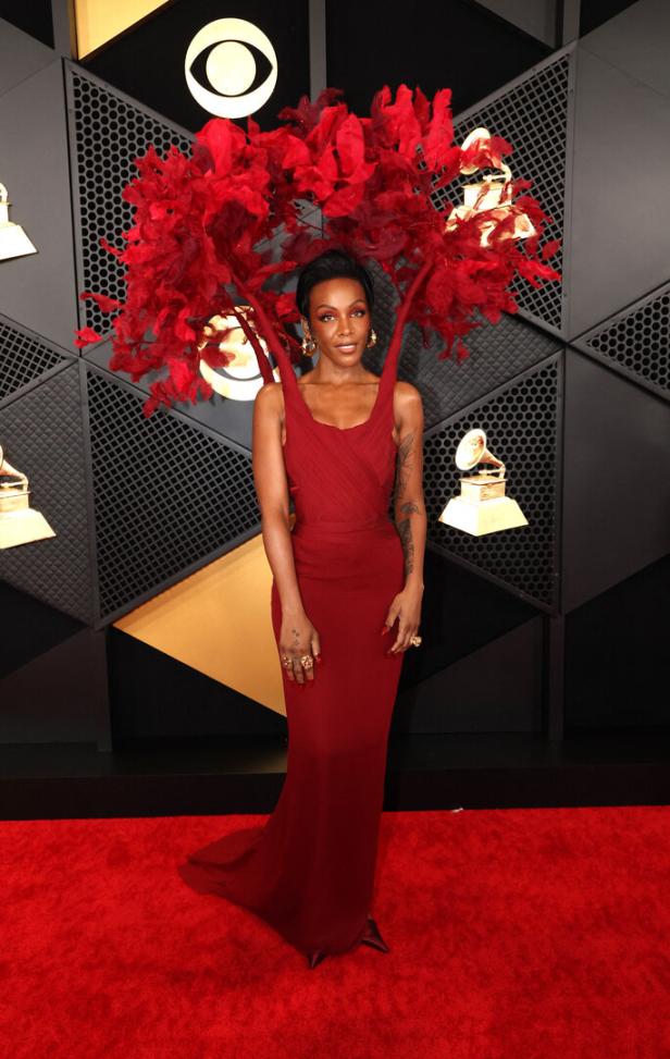 Tierra Whack in einem roten Kleid und einer extravaganten Kopfbedeckung auf dem roten Teppich.