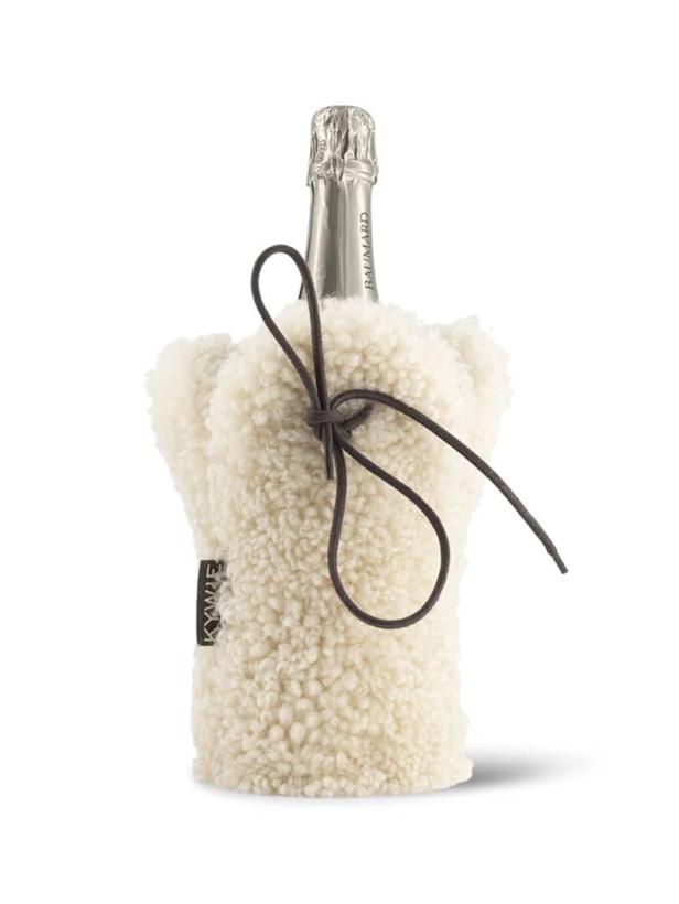 Eine Champagnerflasche in einem flauschigen, weißen Kühler mit brauner Kordel.