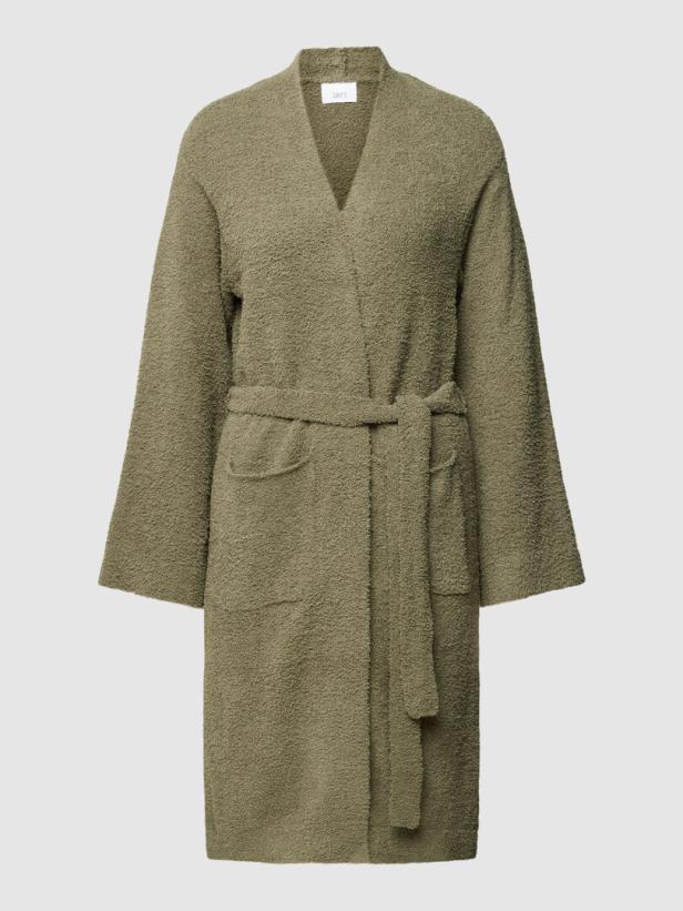 Ein olivgrüner Bademantel mit Bindegürtel und Taschen vor einem neutralen Hintergrund.