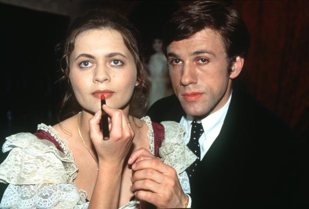 Christoph Waltz und eine Frau mit Lippenstift in einem eleganten Kleid.