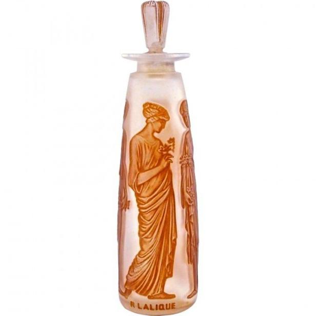 Ein Lalique-Parfümflakon mit Abbildungen von Frauen in Gewändern.