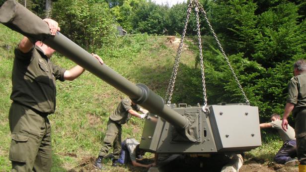Soldaten montieren ein Geschützrohr mit einem Kran im Freien.