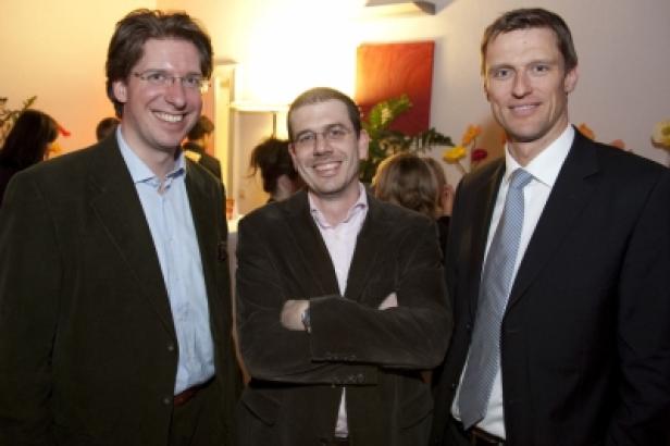 Drei Männer posieren für ein Foto bei einer Veranstaltung.