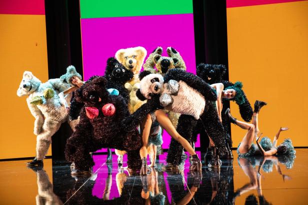 Eine Gruppe von Performer:innen in Bärenkostümen auf einer Bühne.