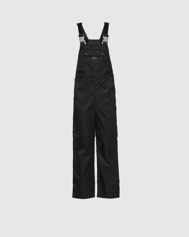 Eine schwarze Prada-Latzhose vor einem hellgrauen Hintergrund.