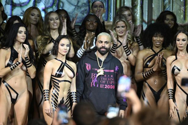 Joel Alvarez mit mehreren Frauen, die mit schwarzem Klebeband bekleidet sind.