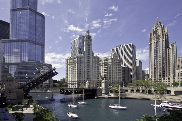 Blick auf den Chicago River mit geöffneter Brücke und mehreren Segelbooten vor der Skyline.
