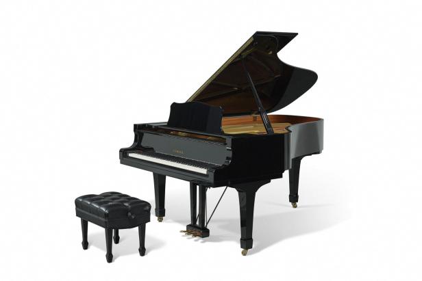 Ein schwarzer Yamaha-Flügel mit geöffnetem Deckel und einem Hocker steht auf einem weißen Hintergrund.