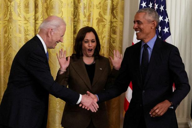 Joe Biden und Barack Obama schütteln die Hände, Kamala Harris steht in der Mitte