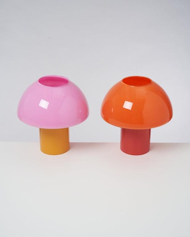Zwei dekorative Pilzlampen in Rosa und Orange stehen auf einem Tisch.