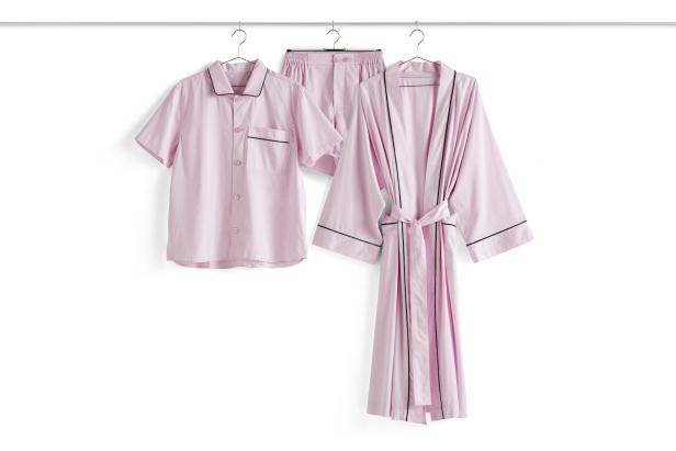 Ein rosa Pyjama-Set und ein passender Morgenmantel hängen an einer Stange.