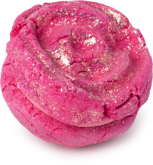 Ein rosafarbener Badezusatz mit goldenem Glitzer in Form einer Rose.