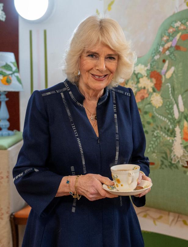 Königin Camilla hält eine Tasse Tee in ihren Händen.