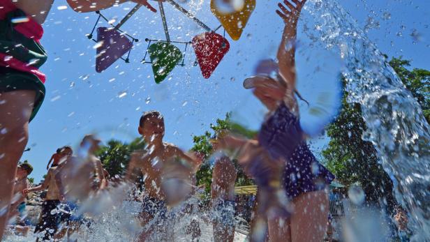 Kinder spielen an einem sonnigen Tag mit Wasser in einem Wasserpark.