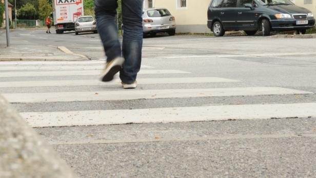 Eine Person überquert einen Zebrastreifen auf einer Straße.