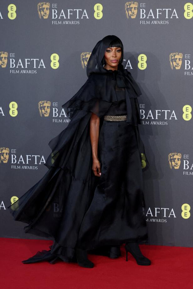 Naomi Campbell trägt ein schwarzes Chanel-Kleid.
