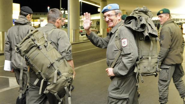 Eine Gruppe Soldaten mit großen Rucksäcken verabschiedet sich.