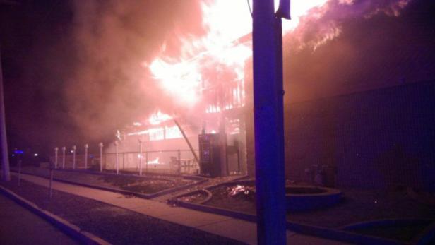 Ein Gebäude steht in Flammen und erzeugt dichten Rauch.