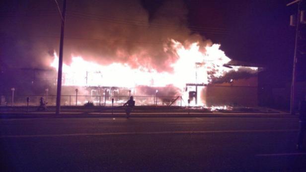 Ein Gebäude steht in Flammen, Rauch steigt auf.