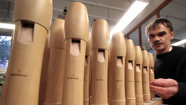 Ein Mann betrachtet eine Reihe neuer Blockflöten der Marke Mollenhauer.
