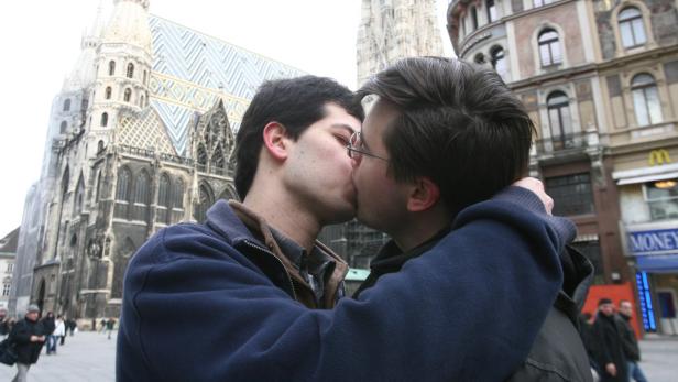 Ein schwules Paar küsst sich vor dem Stephansdom in Wien.
