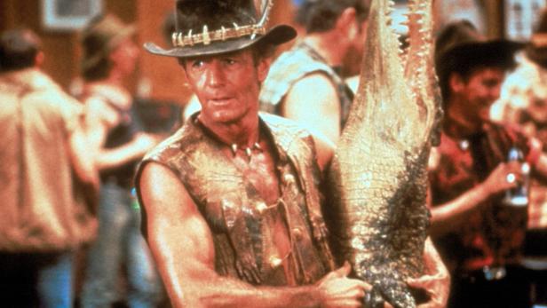 Paul Hogan hält in „Crocodile Dundee“ einen Alligator in den Armen.
