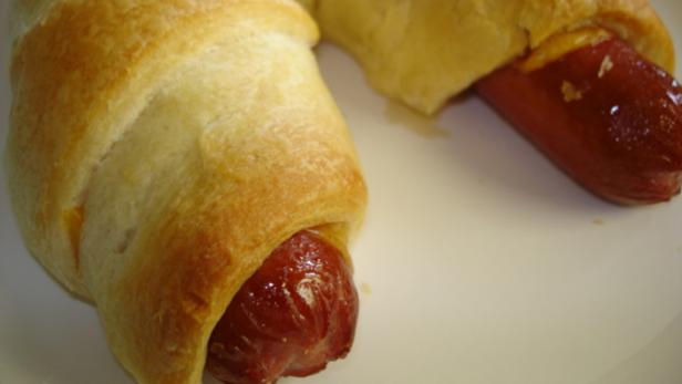 Zwei Hotdogs im Schlafrock auf einem weißen Teller.