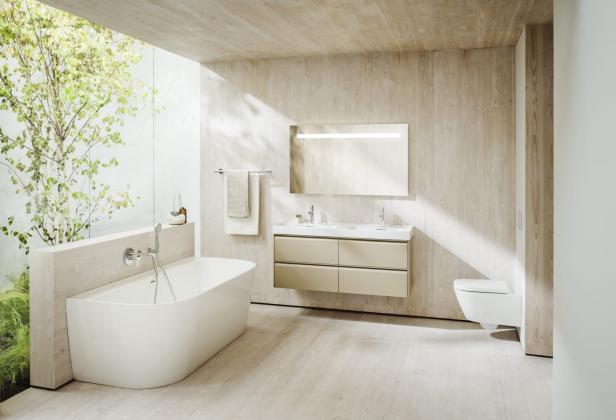 Ein helles Badezimmer mit Holzwänden, einer Badewanne und einem Doppelwaschtisch.