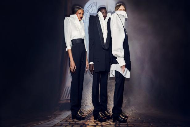 Drei Models präsentieren elegante, avantgardistische Mode in Schwarz und Weiß.