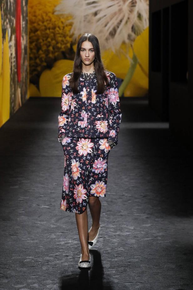 Ein Model auf dem Laufsteg trägt ein Chanel-Ensemble mit Blumenmuster.