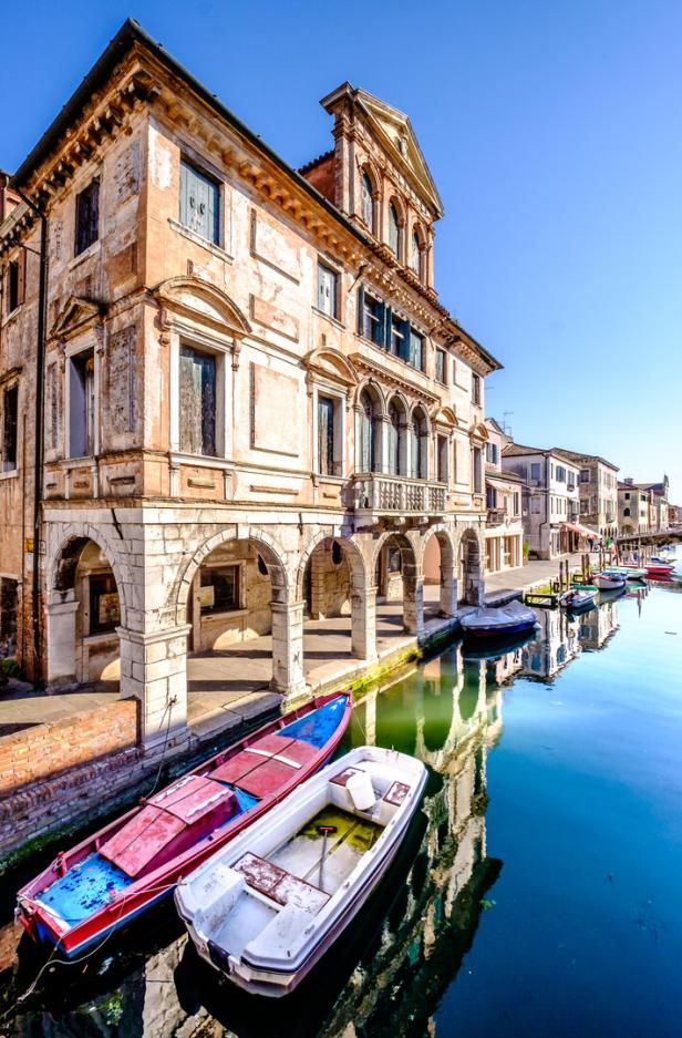 Blick auf Chioggia, auch bekannt als „Klein-Venedig“, mit Booten an einem Kanal.