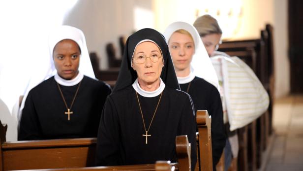 Drei Nonnen sitzen in einer Kirchenbank.