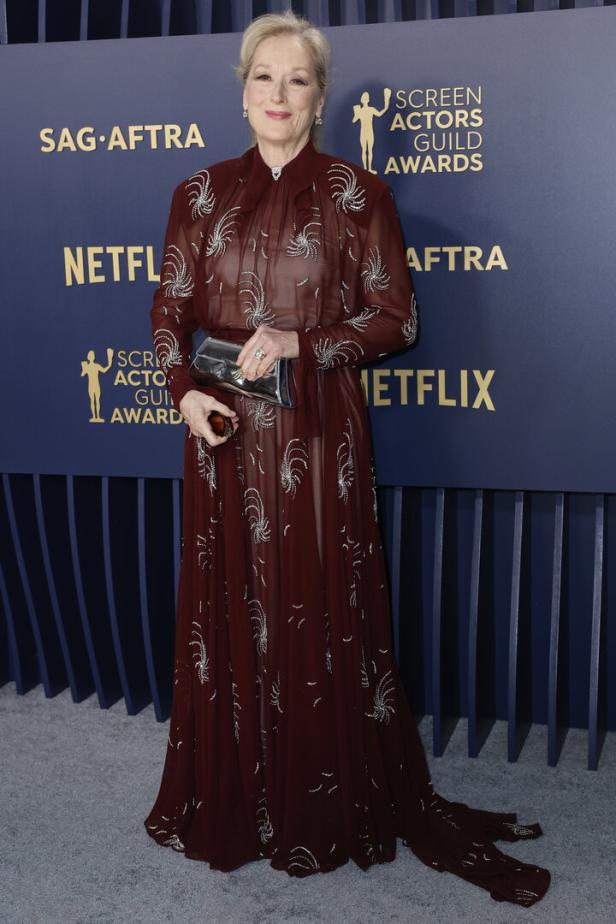 Meryl Streep auf dem roten Teppich in einem langen, burgunderroten Kleid mit silbernen Verzierungen.