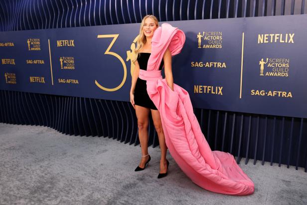 Margot Robbie bei den Screen Actors Guild Awards in einem schwarzen Kleid mit rosa Schleppe.
