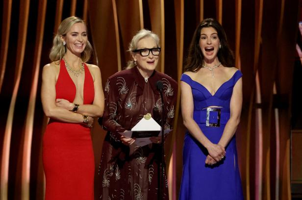 Emily Blunt, Meryl Streep und Anne Hathaway stehen auf einer Bühne.